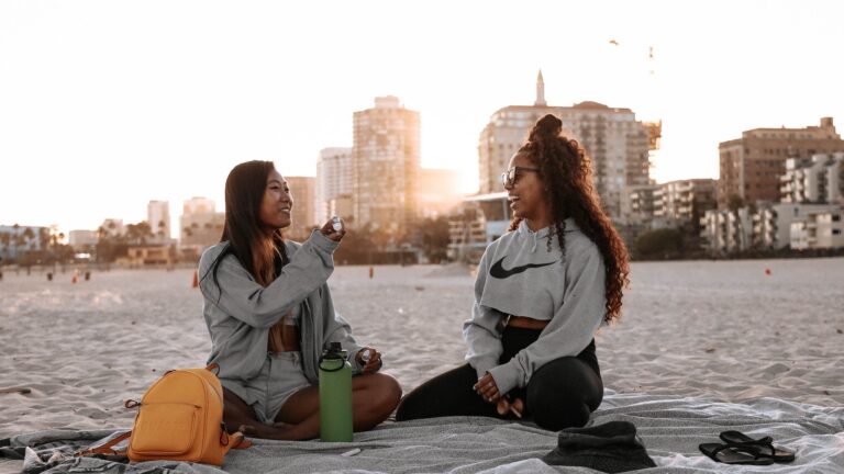 Two women on the beach in athletic clothes from a brand that is LGBTQ-friendly