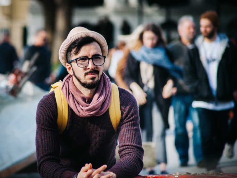 Queer travelers in a group, with a man in a hat in the foreground.