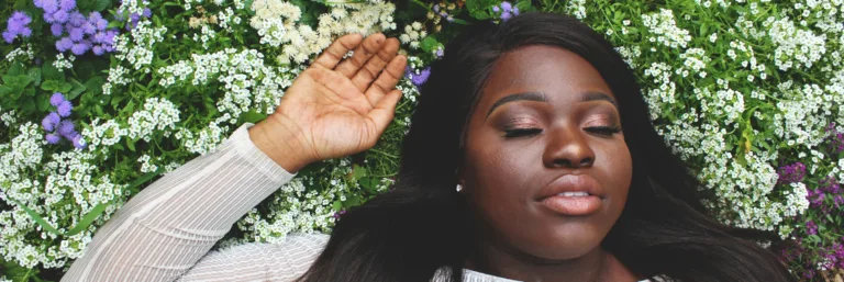 A black woman relaxing in a field of flowers