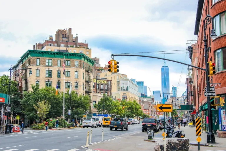 A New York City block with tall buildings, traffic lights and streets.