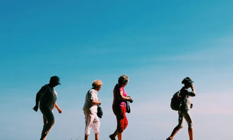 Four older women walking single file