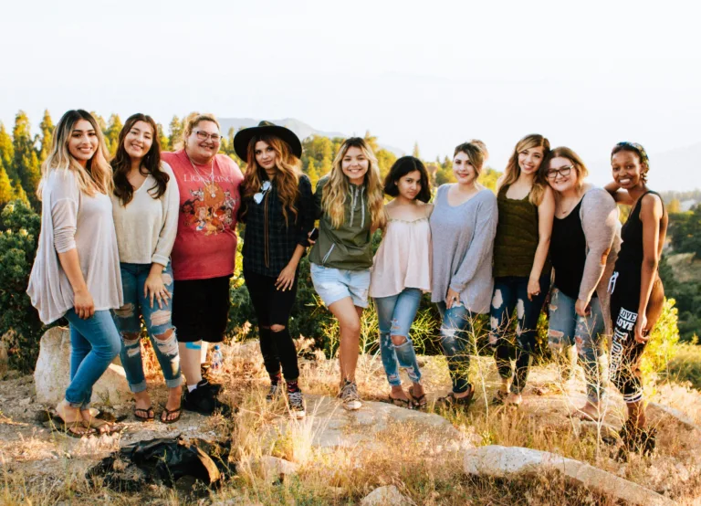 A diverse group of women posing for a photo on a hike