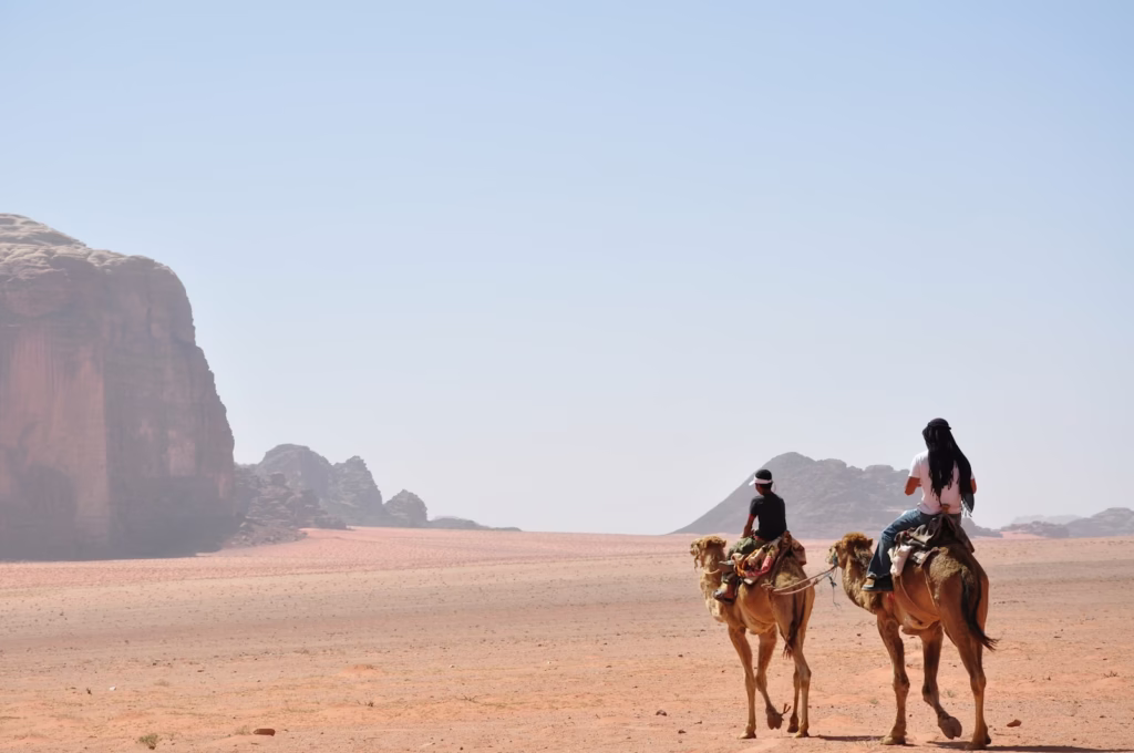 Two people riding on camels in the desert